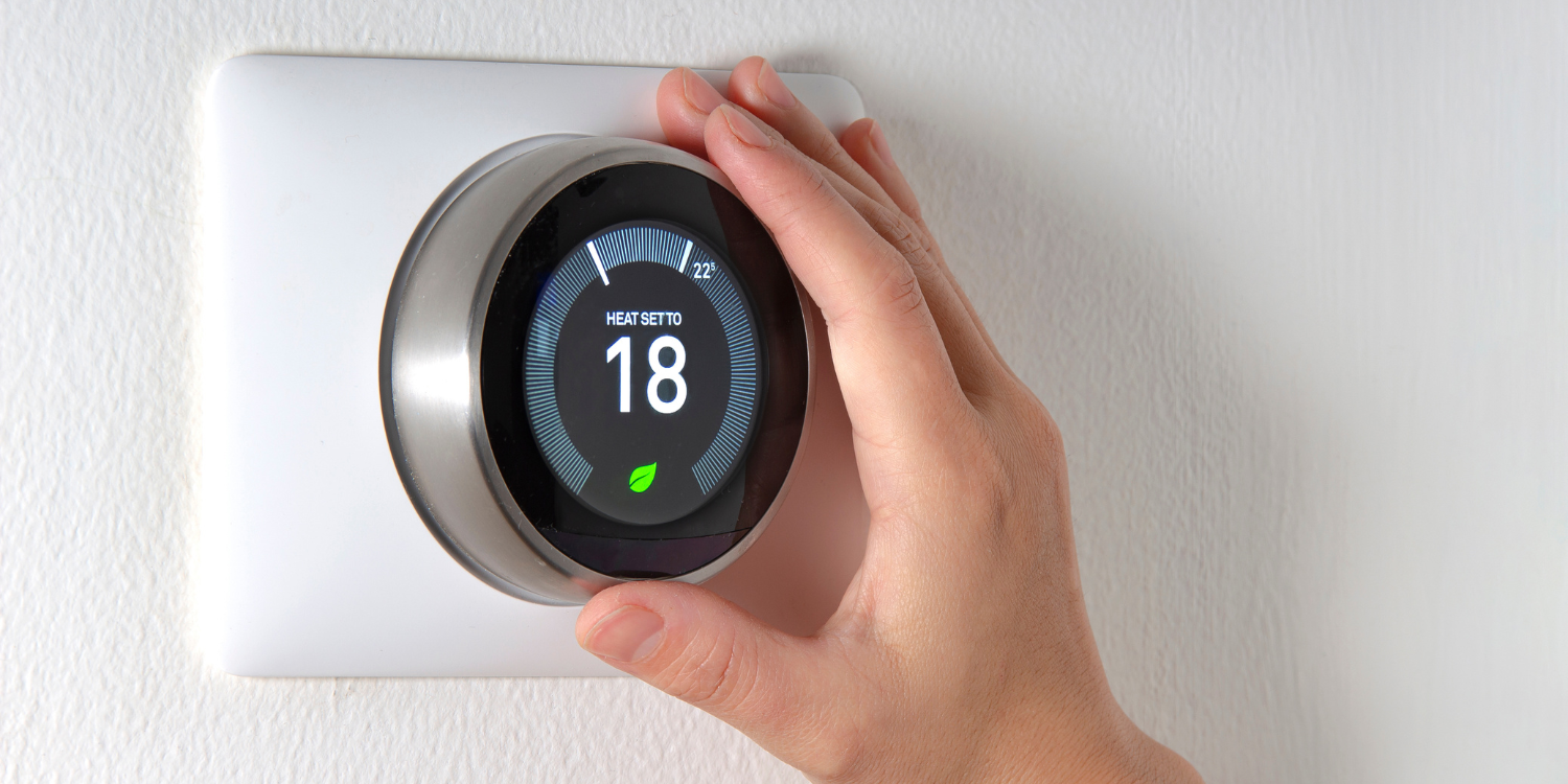 Person adjusting Smart Thermostat - Everything You Need to Know About Smart Thermostats